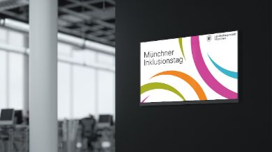 Schild mit der Aufschrift "Münchner Inklusionstag" auf einer Wand eines Veranstaltungsraumes